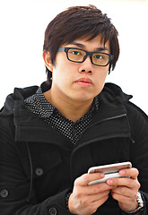 Image showing asian man sms on cell phone