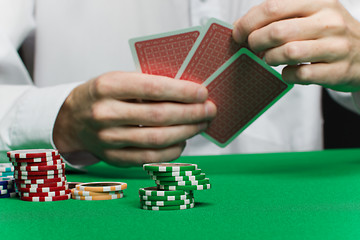 Image showing poker chips and the player's hand with the cards