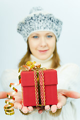 Image showing girl in winter hat gives gift box