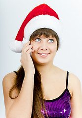 Image showing happy smiling girl with Santa hat with a phone