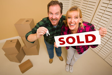 Image showing Goofy Couple Holding Key and Sold Sign Surrounded by Boxes