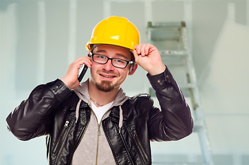 Image showing Contractor in Hard Hat on Cell Phone In Unfinished House