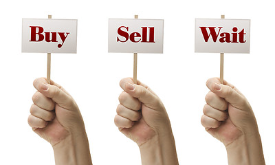 Image showing Three Signs In Fists Saying Buy, Sell and Wait