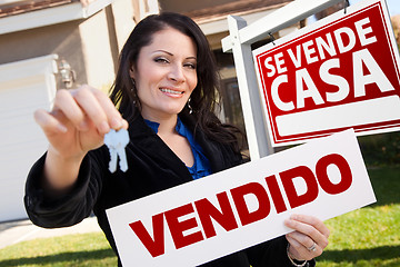 Image showing Hispanic Woman Holding Vendido Sign in Front of Se Vende Casa Si