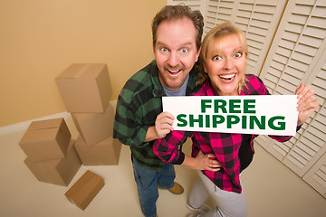 Image showing Goofy Couple Holding Free Shipping Sign Surrounded by Boxes