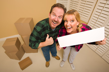Image showing Goofy Goofy Thumbs Up Couple Holding Blank Sign Surrounded by Bo