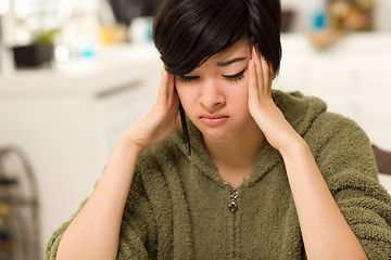 Image showing Multi-ethnic Young Woman Rubbing Her Temples