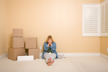Image showing Upset Woman on Floor Next to Boxes and Blank Sign