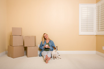 Image showing Relaxing Woman and Dog Next to Boxes on Floor
