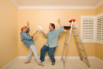 Image showing Fun Couple Playing Sword Fight with Paint Rollers