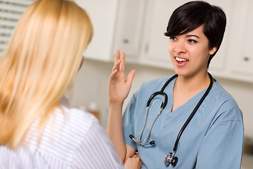 Image showing Attractive Mixed Race Young Female Doctor Talking with Patient