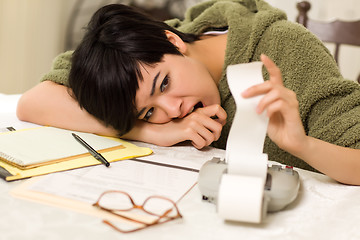 Image showing Multi-ethnic Young Woman Agonizing Over Financial Calculations
