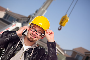 Image showing Young Cunstruction Worker on Cell Phone In Front of Crane