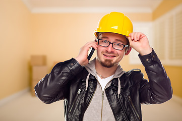 Image showing Young Contractor Wearing Hard Hat on Cell Phone In House