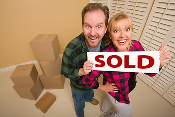 Image showing Goofy Couple Holding Sold Sign Surrounded by Boxes