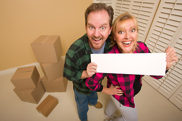 Image showing Happy Couple Holding Blank Sign in Room with Packed Boxes