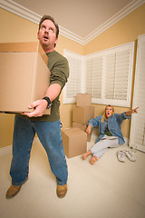 Image showing Stressed Man Moving Boxes for Demanding Wife