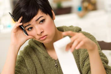 Image showing Multi-ethnic Young Woman Agonizing Over Financial Calculations