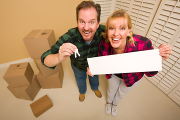 Image showing Goofy Couple Holding Keys and Blank Sign Surrounded by Boxes