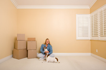 Image showing Pretty Woman and Dogs with Moving Boxes in Room on Floor