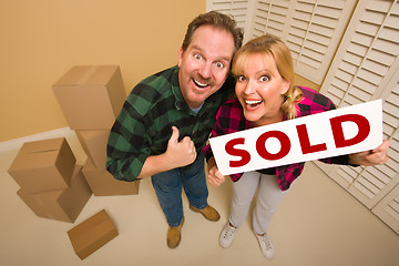 Image showing Goofy Couple Holding Sold Sign Surrounded by Boxes