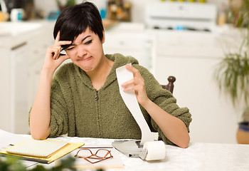 Image showing Multi-ethnic Young Woman Agonizing Over Financial Calculations