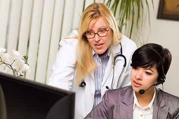 Image showing Female Doctor Discusses Work on Computer with Receptionist Assis