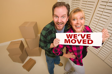 Image showing Goofy Couple Holding We've Moved Sign Surrounded by Boxes