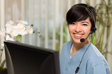 Image showing Attractive Multi-ethnic Young Woman Wearing Headset and Scrubs