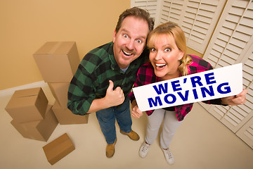 Image showing Goofy Couple Holding We're Moving Sign Surrounded by Boxes