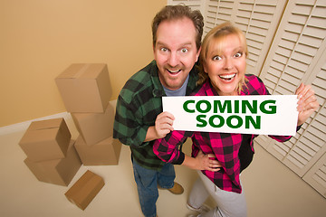 Image showing Goofy Couple Holding Coming Soon Sign in Room with Boxes