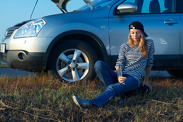 Image showing Young Blond Woman With Her Broken Car