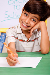 Image showing Portrait of cheerful boy writing notes