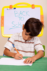 Image showing Portrait of a young boy writing notes