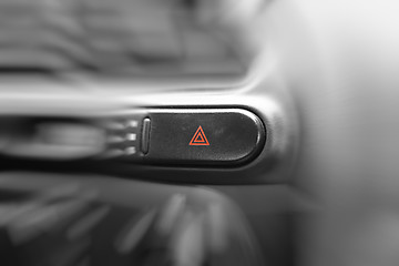 Image showing Car emergency lights button on cockpit. Very shallow DOF.
