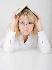 Image showing girl in glasses hidden under a book