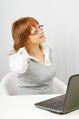 Image showing tired girl with a laptop stretches