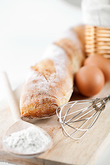 Image showing still life of bread, flour, eggs and kitchen utensil