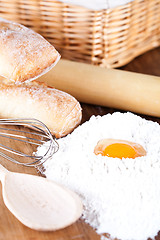 Image showing still life of bread, flour, eggs and kitchen utensil 