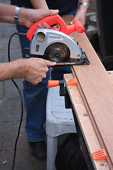 Image showing construction worker cutting wood with circular saw