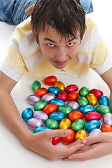 Image showing Boy gathering together easter eggs