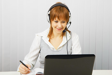 Image showing Attractive girl in a white blouse with a laptop