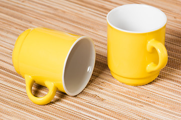 Image showing Two yellow mugs on a table