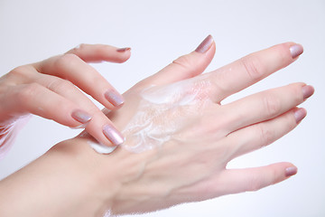 Image showing Woman applying moisturizing cosmetic creams on her hands