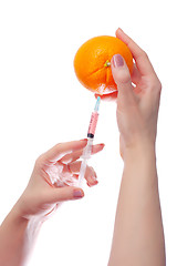 Image showing woman holds in her hands medical suringe and oranges