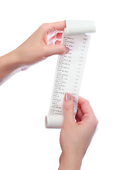 Image showing woman holds in her hands roll of paper with printed receipt 