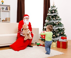 Image showing Santa Claus showing toy from bag