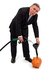 Image showing Business man filling gas in piggy bank