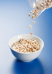 Image showing Popped wheat flakes pouring in plate