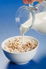 Image showing Pouring milk over wheat popped flakes